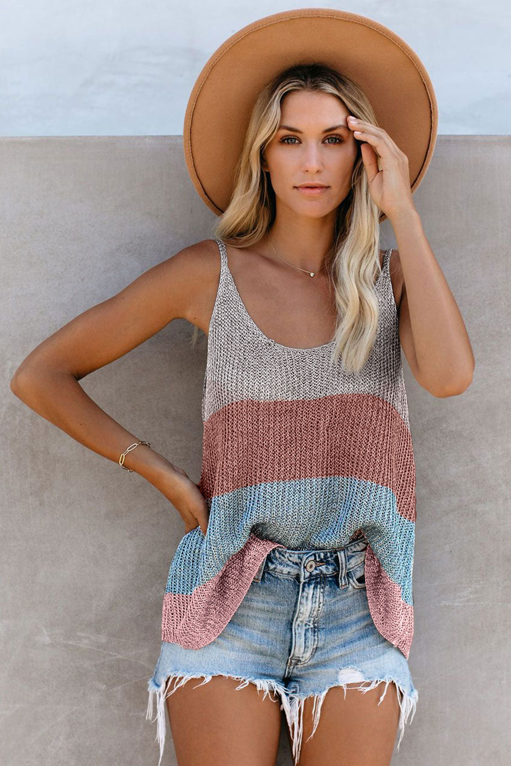 girl posing for photo with tank top and wide brim hat with denim shorts, highlight is on her tanktop